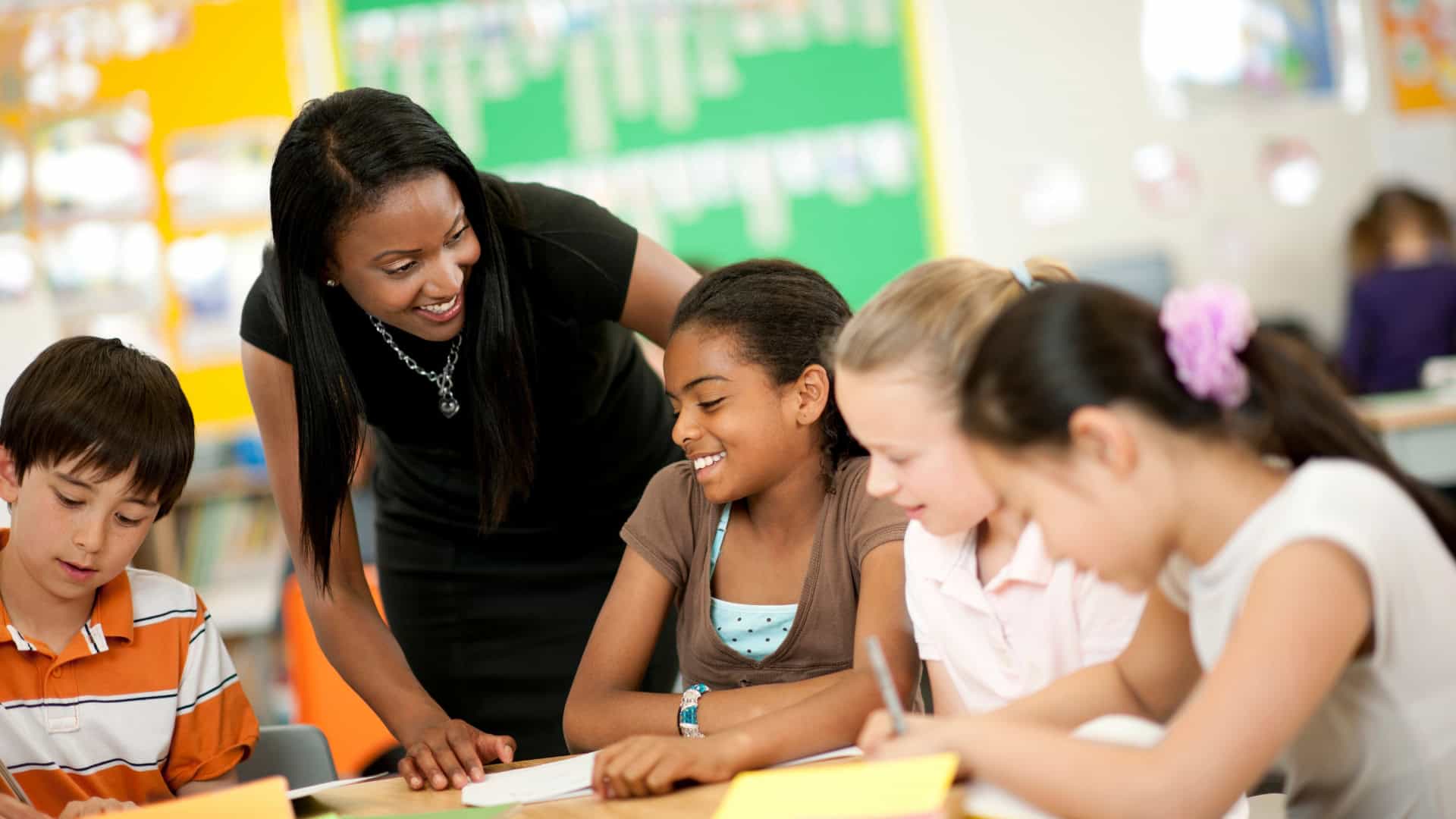 Teacher helping students in a classroom in Delaware